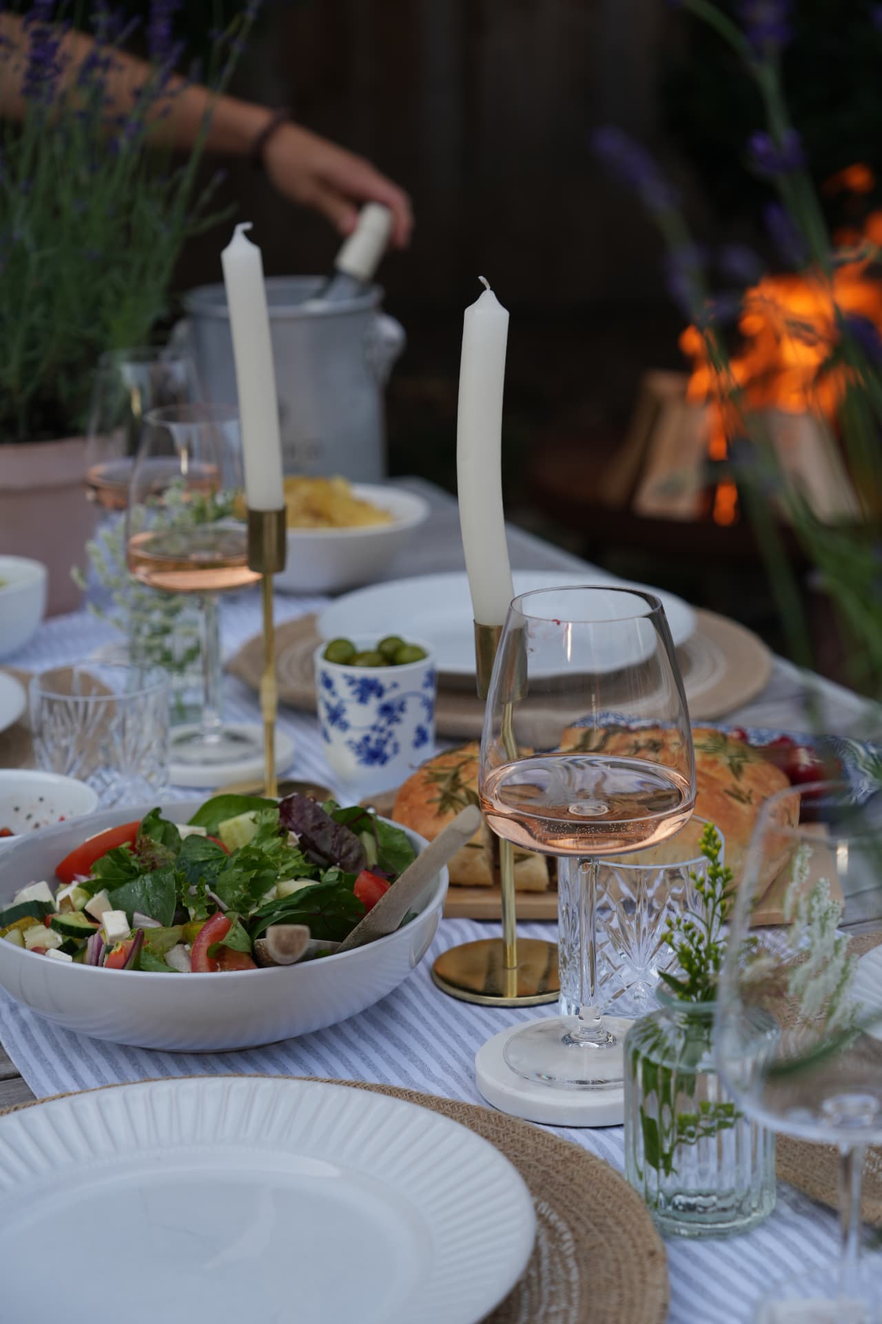 Summer garden table laid with salad, wine and candles